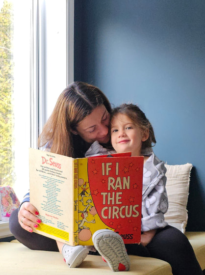 Alex and her daughter reading a book